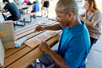 Habitat homeowner plays fun family activity with fellow Habitat homeowners.