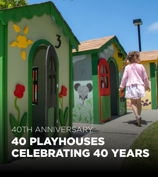 Little girl walking in front of a Habitat for Humanity Playhouse