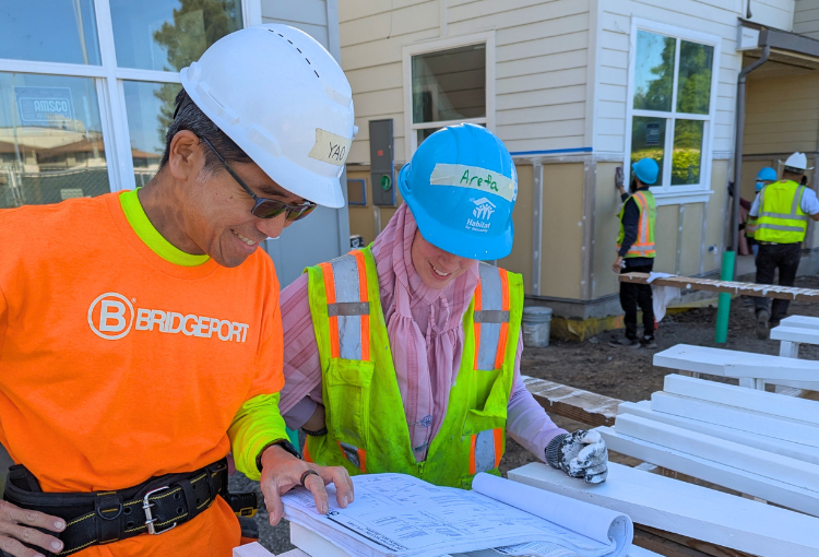 two volunteers read house plans