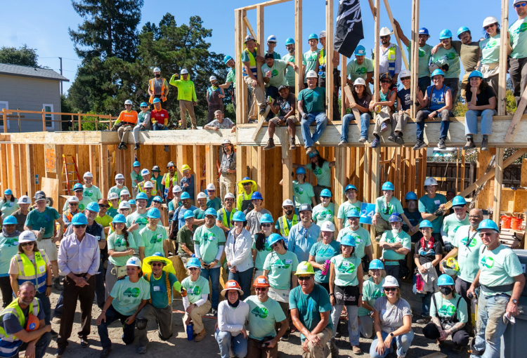 Large group of volunteers in front of a newly-framed home at Esperanza Place