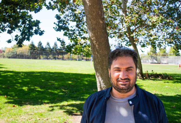 Future homeowner, Khalil, stands in a park