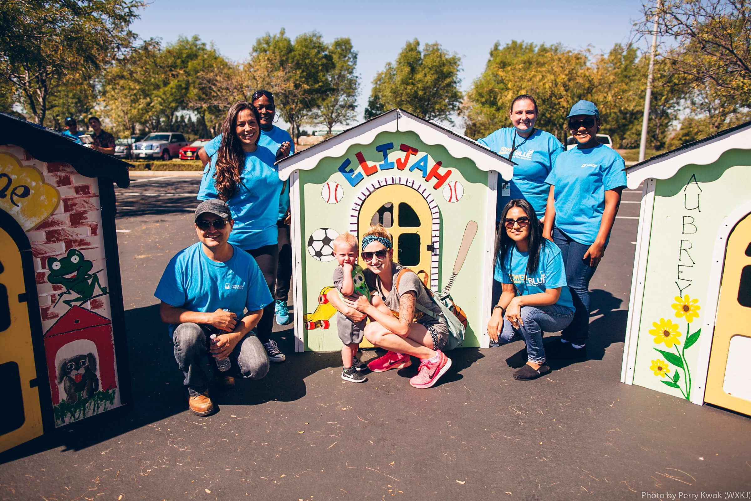Habitat volunteers standing in front of Elijah's new playhouse