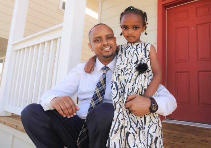 father and daughter standing by their front door