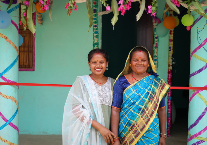 Nepalis family standing in front of their home.