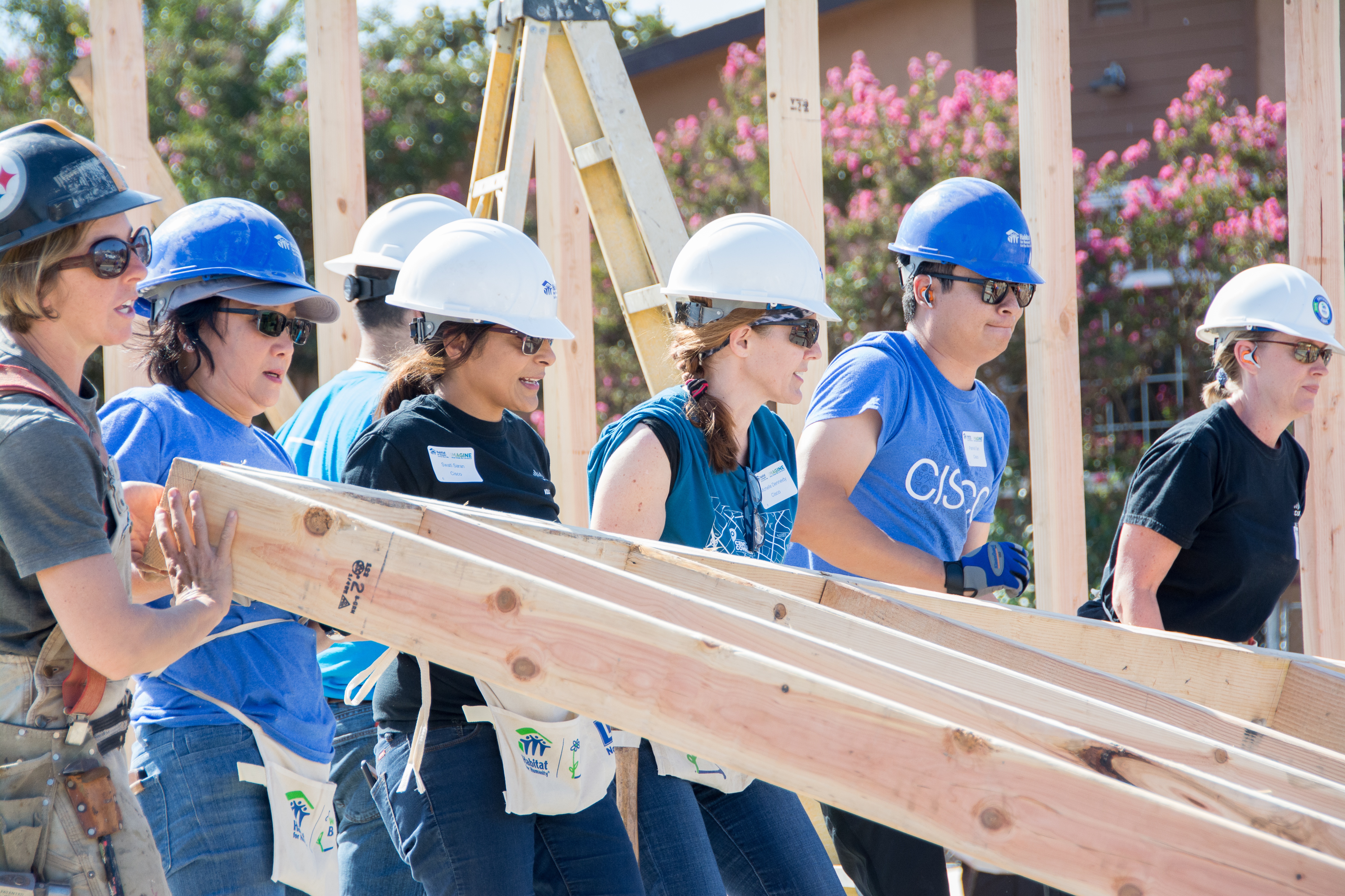 Volunteers raising a framed wall.
