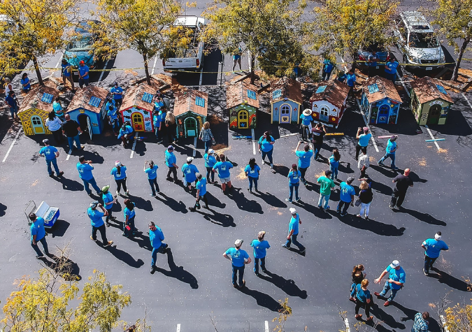 Company volunteers building playhouses.
