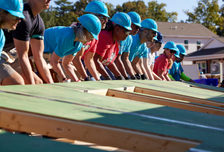 Habitat for Humanity Volunteers Raising a Wall on the build site.
