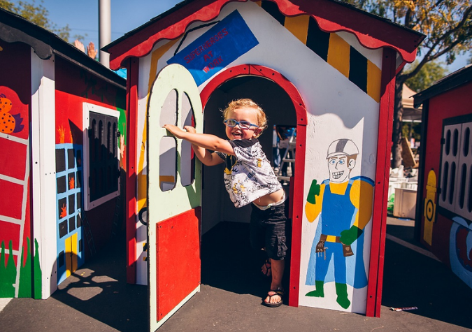 Child in a playhouse built by volunteers